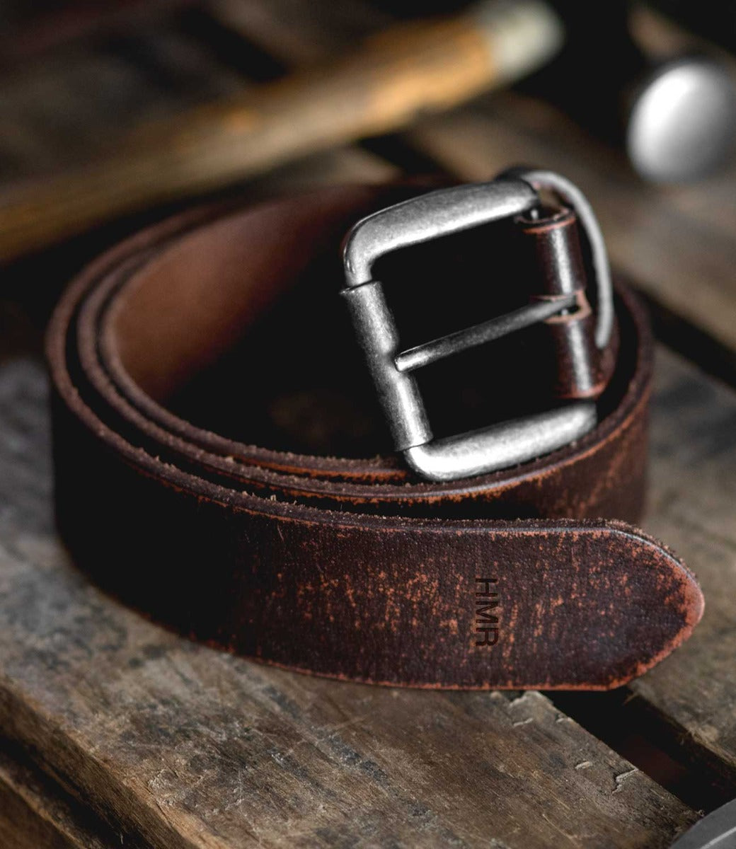 A Drifter brown leather belt by Bed Stu on a wooden table.