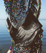 A woman in a sequined dress holding a Bed Stu Eastend purse.