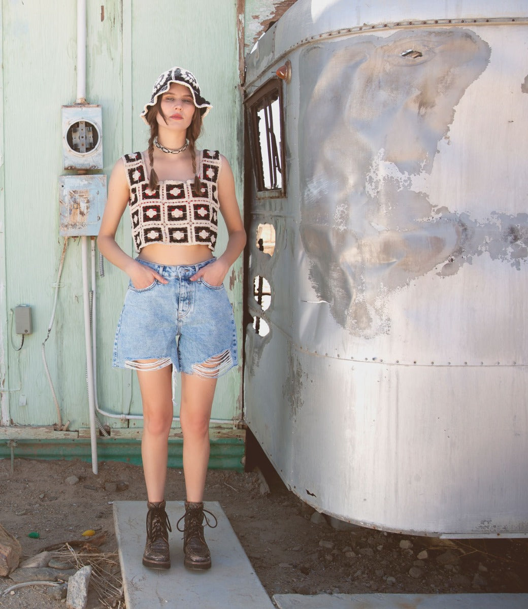 A woman in Bed Stu denim shorts standing in front of a trailer.