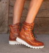 A woman's legs in a pair of Bed Stu Elisha II brown leather boots.