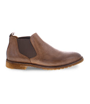 Side view of the Elude single brown leather Chelsea boot by Bed Stu, featuring elastic side panels and a textured sole, showcasing a timeless design.