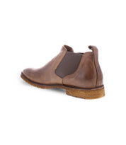 Side view of the Elude, a timeless tan leather Chelsea boot by Bed Stu, featuring a rubber sole, elastic side panel, and pull tab at the back—handcrafted in Italy.