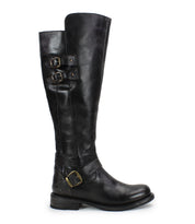 The Bed Stu Essence is a tall black knee-high riding boot with hand-finished leather, three brass buckles, a low stacked heel, and a slightly rounded toe, shown in side profile on a white background.
