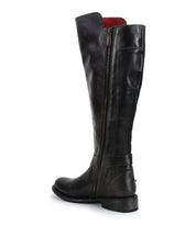 The Bed Stu Essence boot is a tall black hand-finished leather boot with an equestrian design, side zipper, low heel, and slightly rounded toe, shown angled to display the exterior side.
