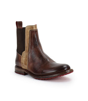 The Bed Stu Ethic brown leather Chelsea boot features vegetable-tanned leather, a tan side panel, dark elastic inserts, a red pull tab, and red sole detailing, shown against a white background.