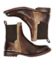 A pair of Bed Stu Ethic Chelsea boots in brown vegetable-tanned leather with beige accents, dark elastic side panels, pull tabs, and red Vibram soles displayed side by side on a white background.