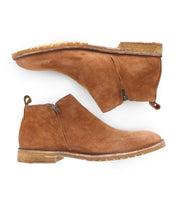 A pair of Evade brown premium suede ankle boots by Bed Stu, featuring dual side zippers, displayed on their sides with one boot's sole facing up.