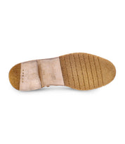 A close-up view of the bottom of a beige Evade shoe by Bed Stu, featuring a textured sole and visible brand label, showcasing its premium suede material.