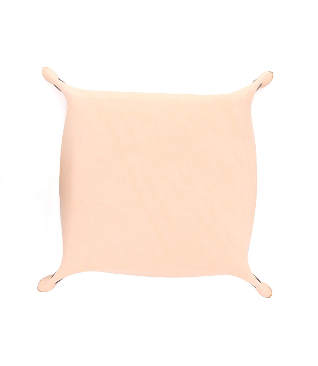 A rectangular piece of beige fabric is stretched with small hooks at the corners against a white background, creating an elegant Bed Stu Expanse Catchall Tray perfect for keys and loose change.