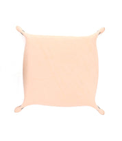 A rectangular piece of beige fabric is stretched with small hooks at the corners against a white background, creating an elegant Bed Stu Expanse Catchall Tray perfect for keys and loose change.