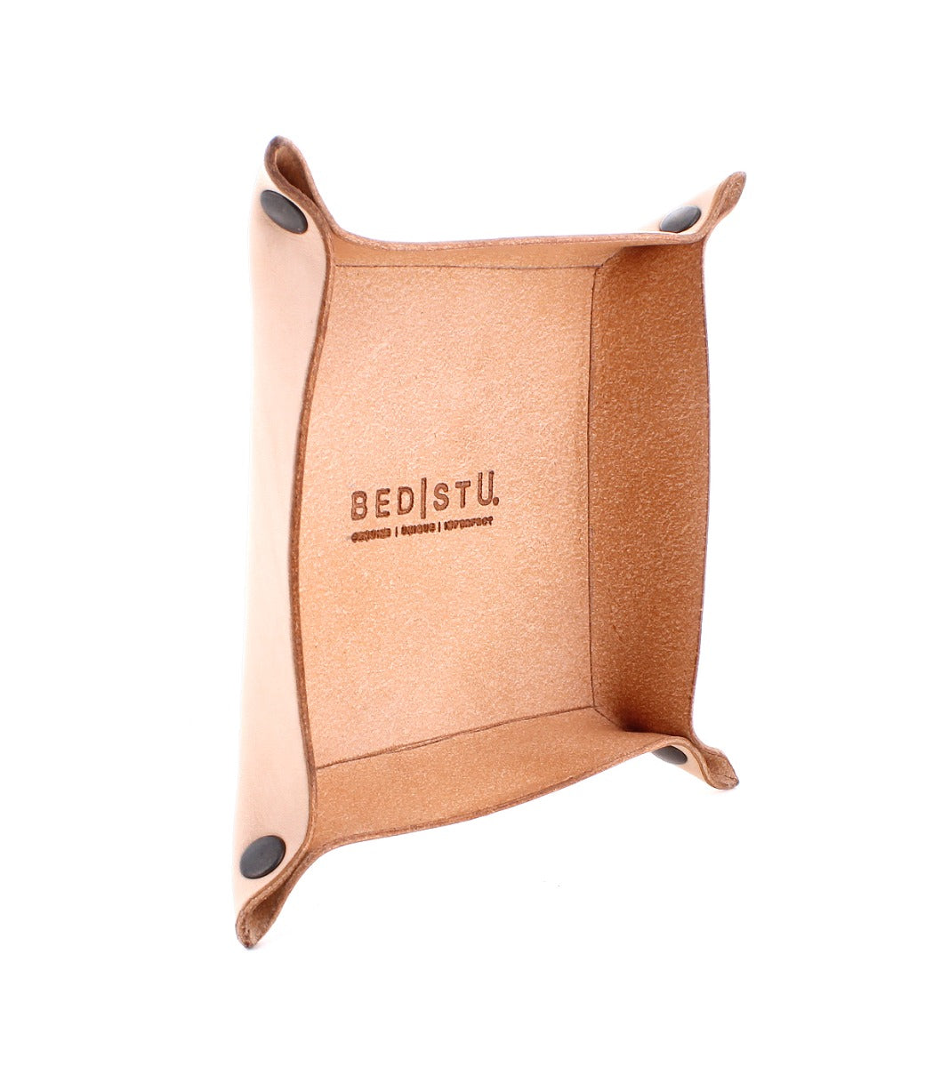 Expanse Catchall Tray with "Bed Stu" branding, four elevated corners secured with metal snaps, perfect for holding loose change and keys, featuring a brown interior and exterior.