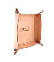 Expanse Catchall Tray with "Bed Stu" branding, four elevated corners secured with metal snaps, perfect for holding loose change and keys, featuring a brown interior and exterior.