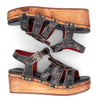 A pair of distressed black Fabiola women's sandals with a wooden platform by Bed Stu.