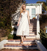 A woman in a white dress walking down stairs wearing the Fairlee II shoes by Bed Stu.