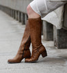A woman wearing caramel leather Fate boots with zipper on the side, made by Bed Stu.