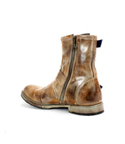 The Fellow boot by Bed Stu, featuring weathered brown leather and side zippers, exudes a rugged, moto-inspired vibe and is showcased against a white background.