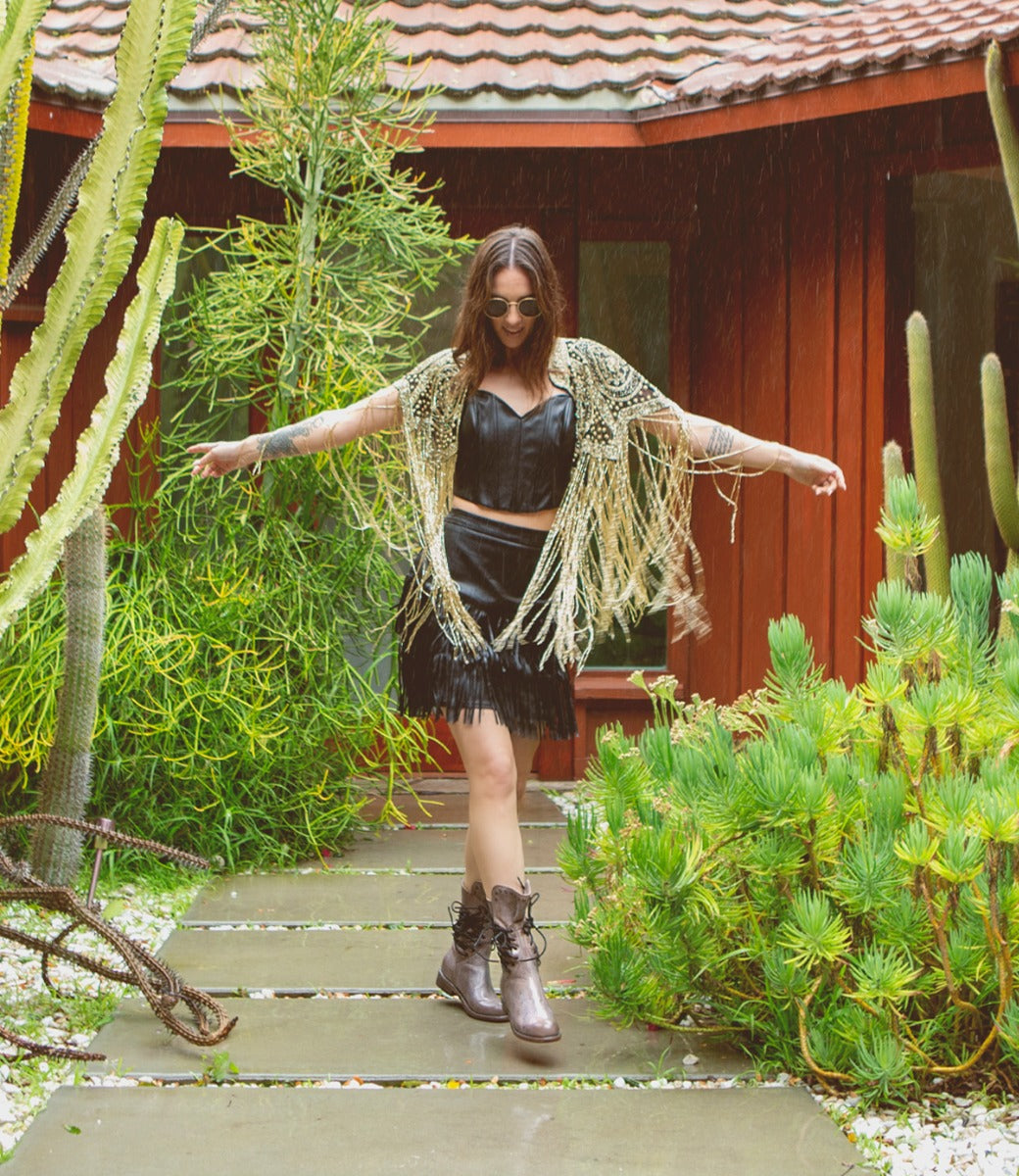 A woman standing in front of Fen by Bed Stu plants.