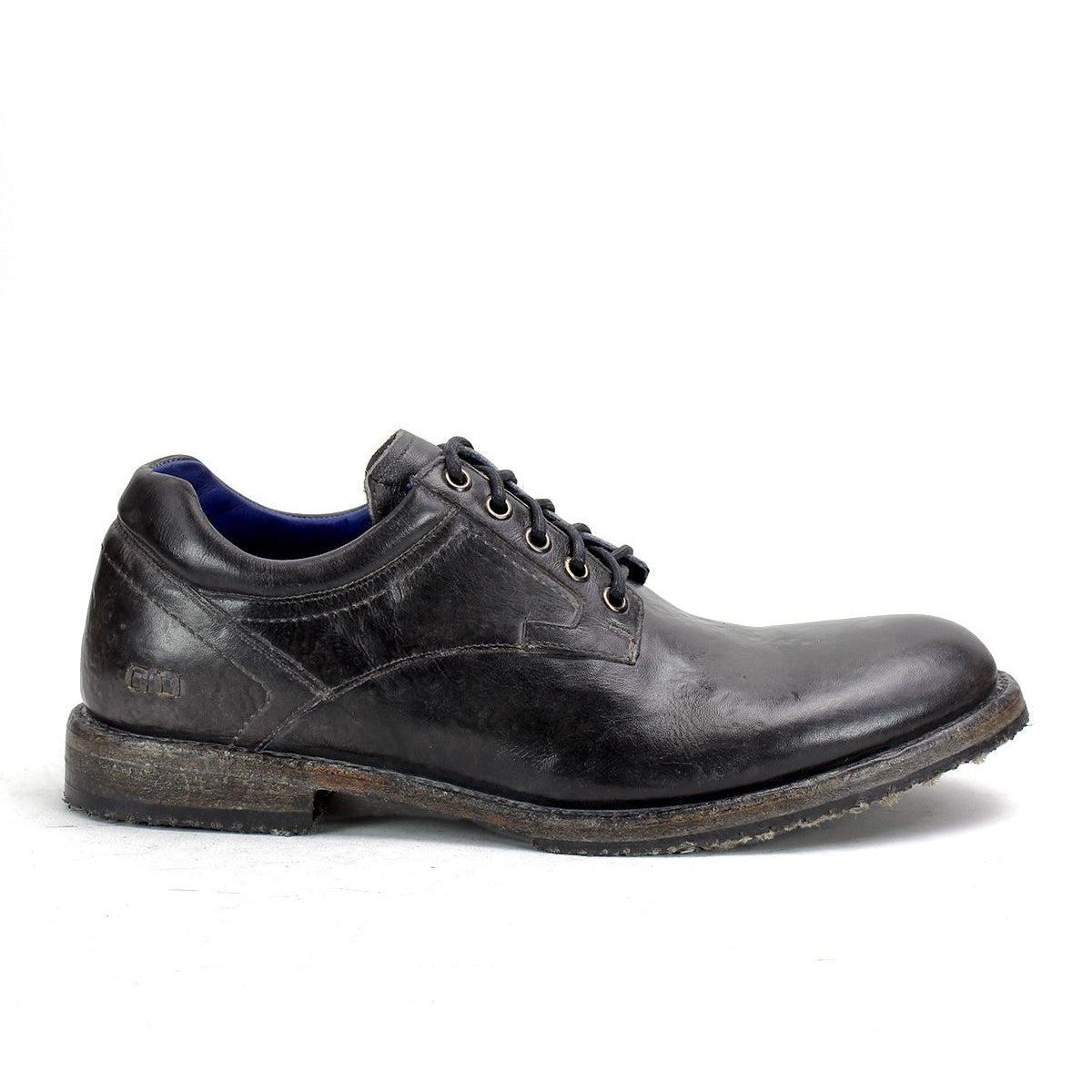 The Bed Stu "Fierce" is a black leather men's derby shoe with laces and a worn-looking sole, combining classic design with modern flair, showcased in side profile against a plain background.