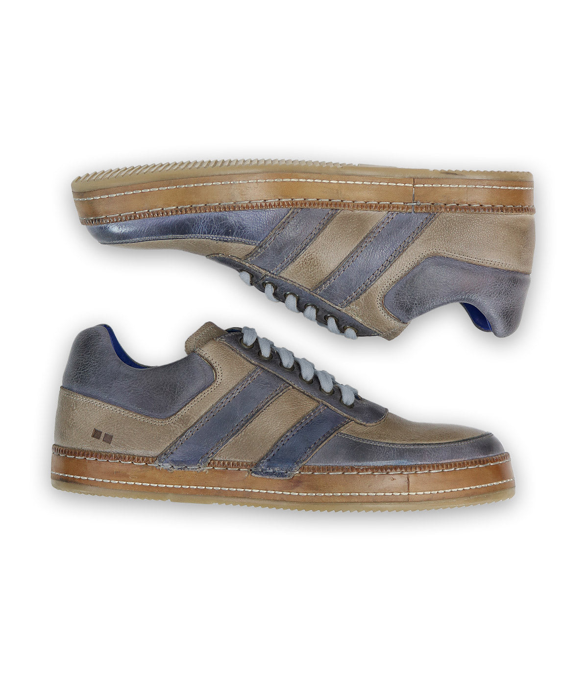 The Firepower sneakers by Bed Stu are men's shoes featuring gray and beige tones, two dark leather stripes on the sides, white laces, and a brown vulcanized sole.