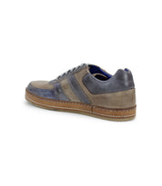 The Bed Stu Firepower sneaker boasts a sleek leather stripe on the side with a vulcanized brown sole, featuring a stylish gray and blue color scheme.
