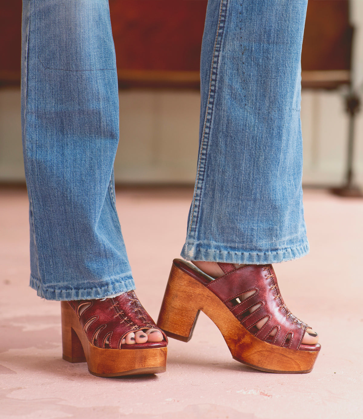 A woman wearing a pair of Fontella jeans and a pair of Bed Stu wooden sandals.