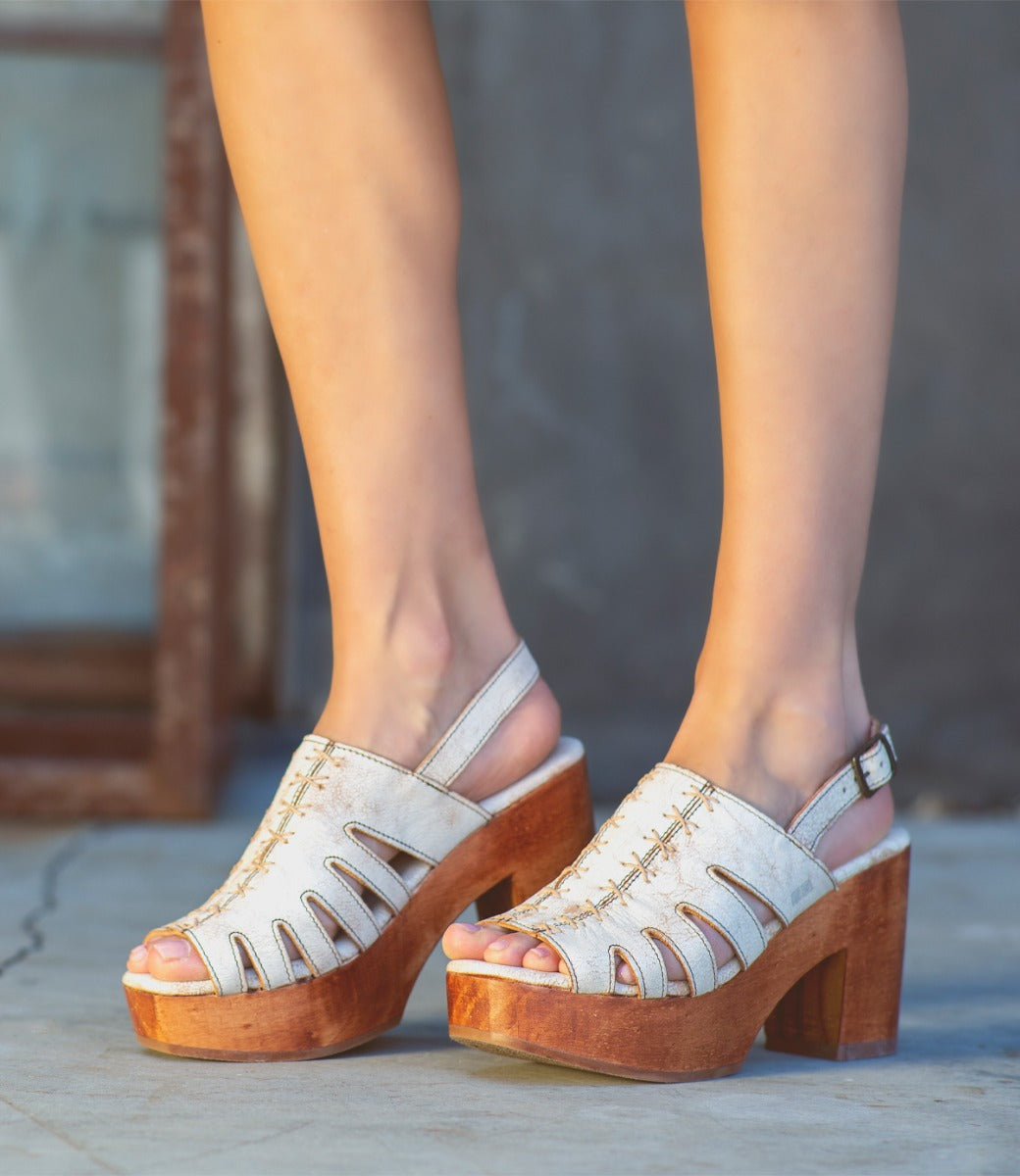 A woman wearing a pair of Fontella by Bed Stu white platform sandals.