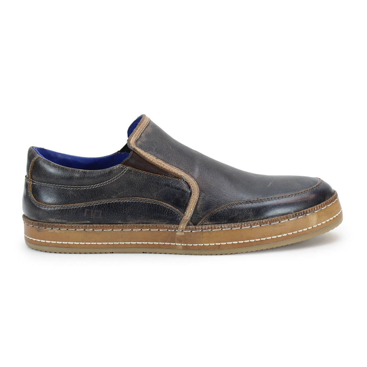 The Bed Stu Freestyle is a brown leather slip-on shoe that exudes casual sophistication, featuring a contrasting lighter brown sole, side stitching, and blue inner lining.