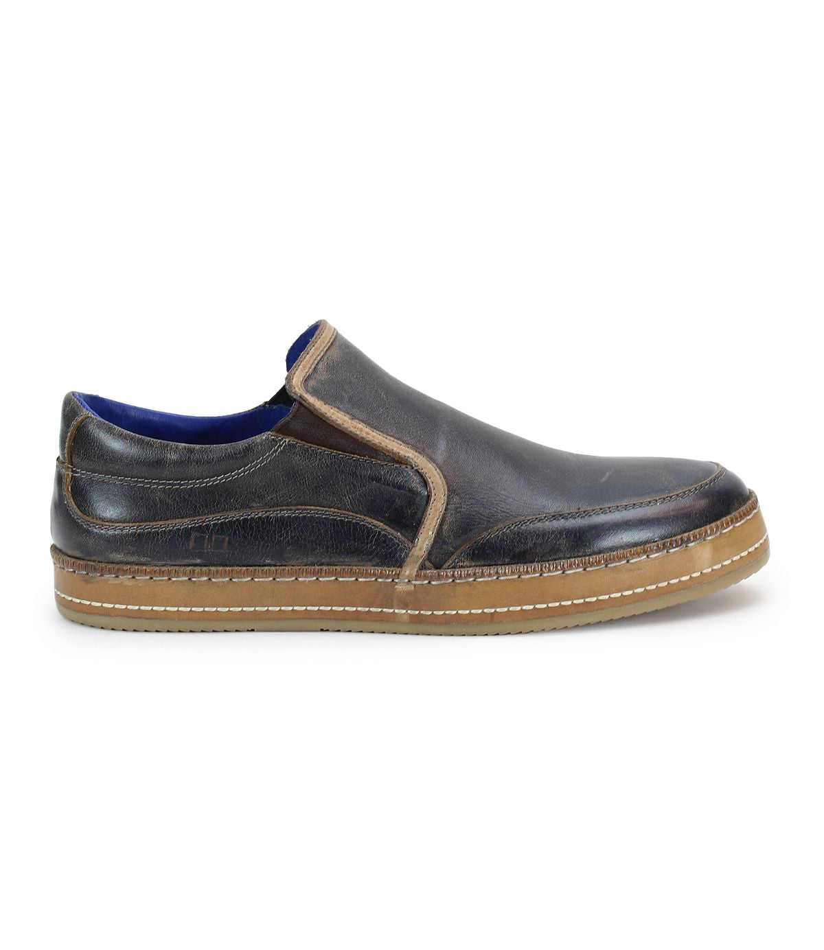 The Bed Stu Freestyle is a brown leather slip-on shoe that exudes casual sophistication, featuring a contrasting lighter brown sole, side stitching, and blue inner lining.