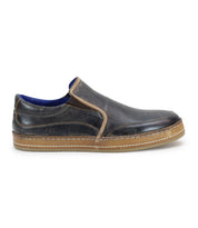 The Bed Stu Freestyle is a brown leather slip-on shoe that exudes casual sophistication, featuring a contrasting lighter brown sole, side stitching, and blue inner lining.