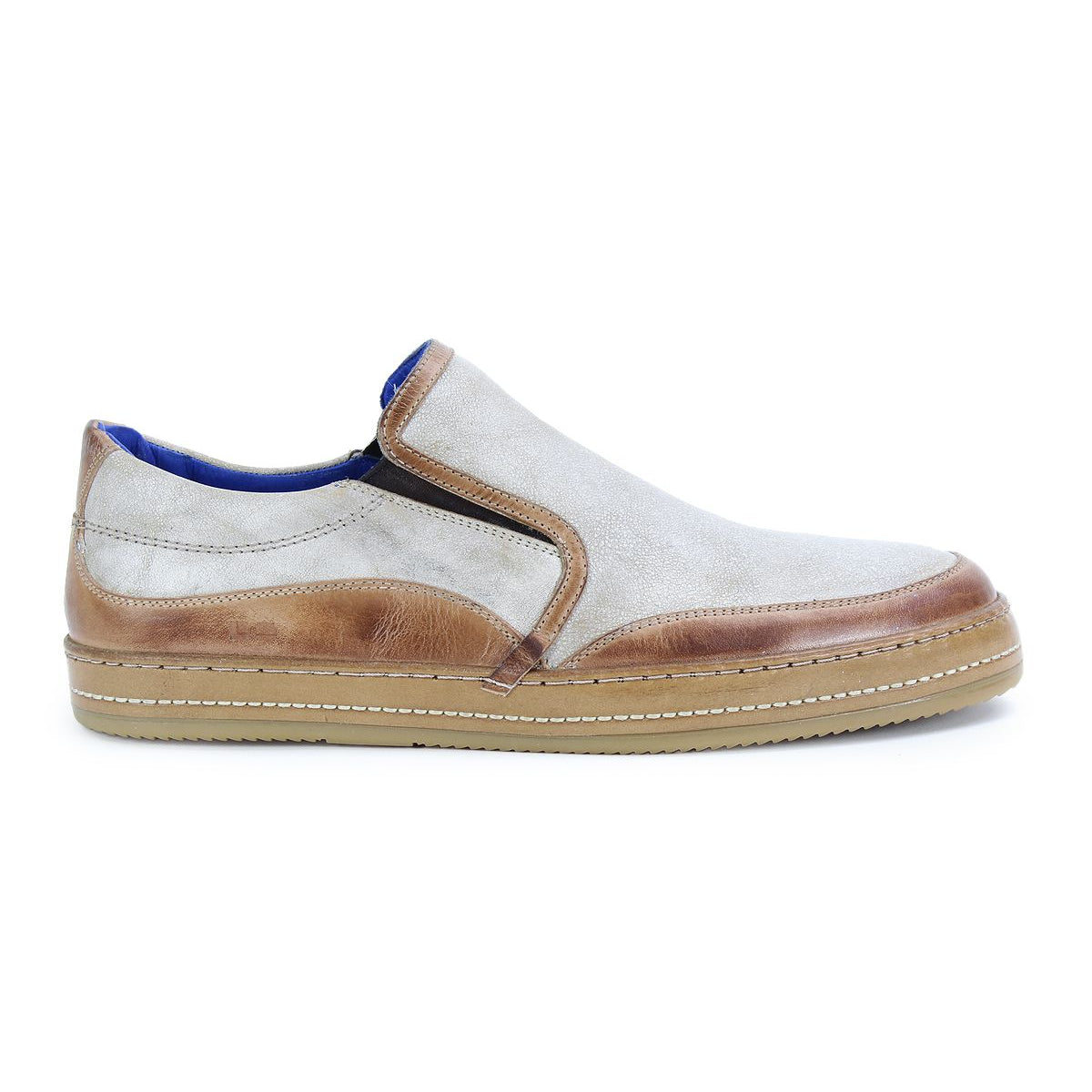 The Bed Stu Freestyle is a casual slip-on sneaker with a light beige fabric upper, leather detailing, and a tan rubber sole.