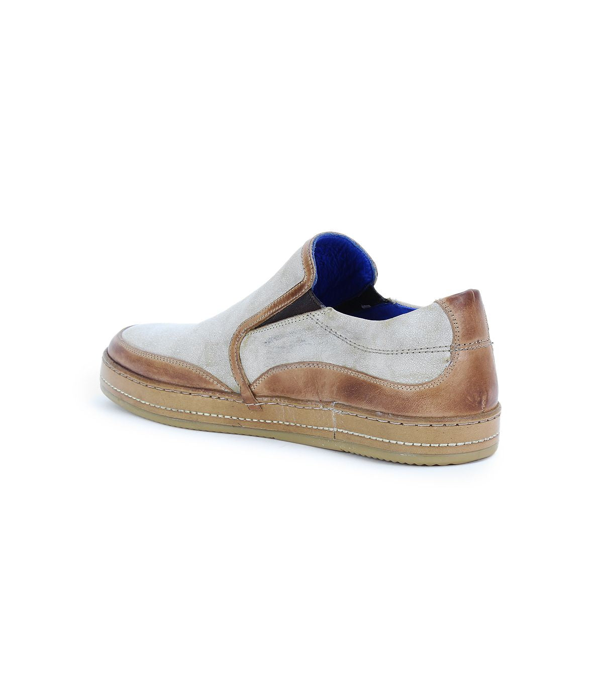 The Bed Stu Freestyle is a casual slip-on sneaker featuring a beige body, darker brown leather accents, and a light brown sole for a stylish look.