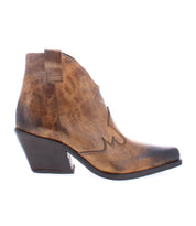 The Furio by Bed Stu is a Western-inspired boot made from brown leather, featuring a pointed toe, decorative stitching, and a low block heel, all meticulously handcrafted in Italy.
