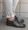 A woman wearing a pair of Bed Stu Galao lace up oxford shoes.