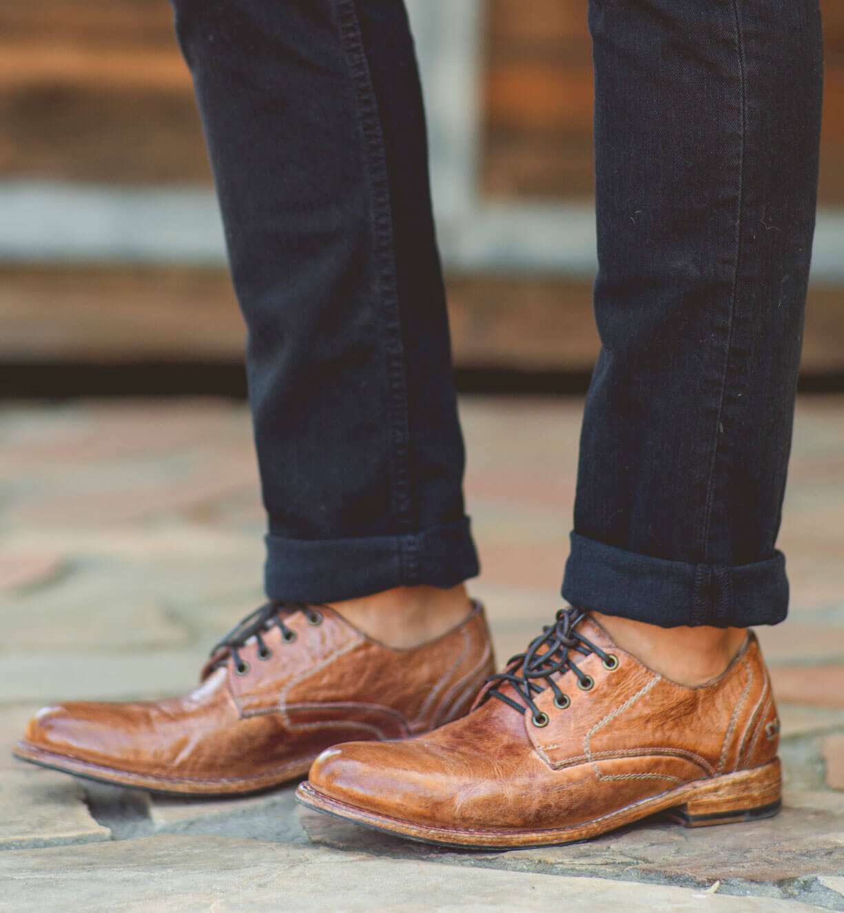 A man wearing a pair of brown Bed Stu Galao shoes.