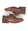A pair of Bed Stu Garden M brown shoes with red soles.
