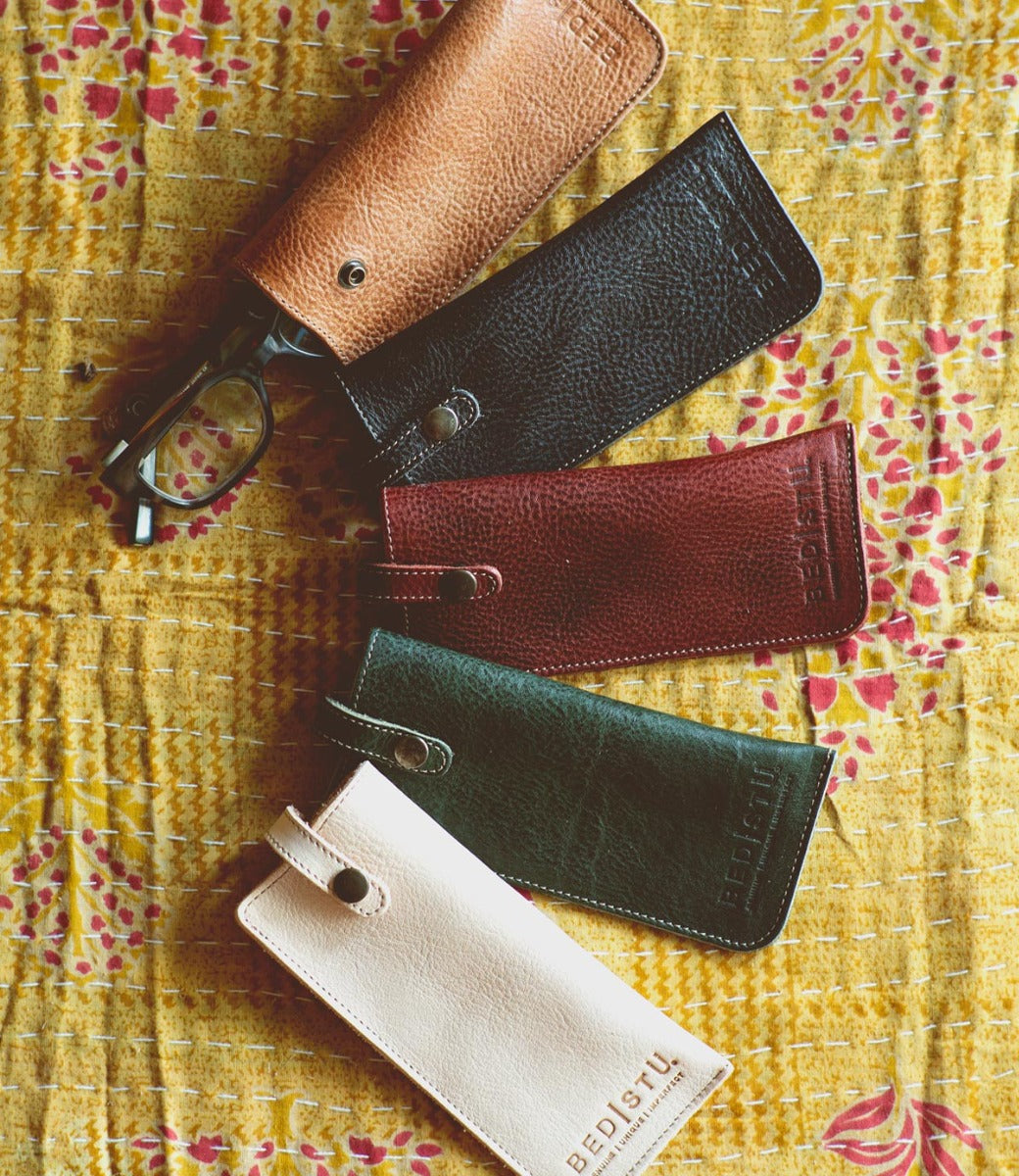 A group of different colored Bed Stu Behold leather eyeglasses on a table.