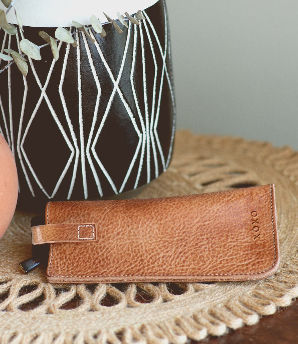 A brown leather Behold eyeglass case sitting on a table. (Brand: Bed Stu)