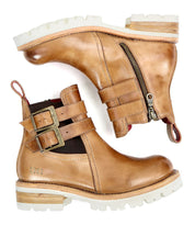The Ginger II by Bed Stu are a pair of tan leather Chelsea ankle boots featuring inner zippers, buckle straps, and white rubber soles for stylish touches.