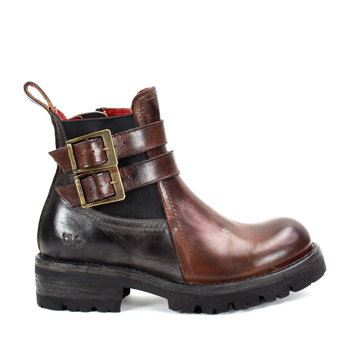 The Ginger II by Bed Stu is a brown leather Chelsea ankle boot, featuring two buckled straps on the side, a pull tab at the heel, and a thick black sole. It also includes stylish touches such as an inner zipper for easy wear.