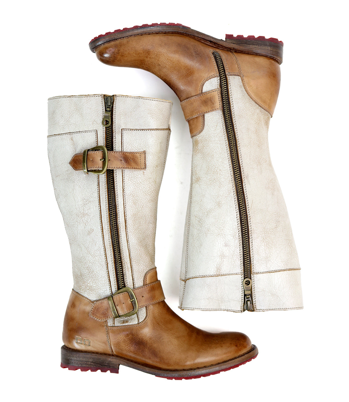 A pair of "Gogo Lug" mid-calf leather boots by Bed Stu with brown leather soles, light beige shafts, and decorative buckles. The boots feature dual zippers for easy wear and a durable lug outsole for added traction.