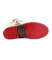 A white leather Gogo Lug Wide Calf boot with a durable red lug outsole and rugged tread pattern lies on its side, displaying the brand name "Bed Stu" on the bottom.