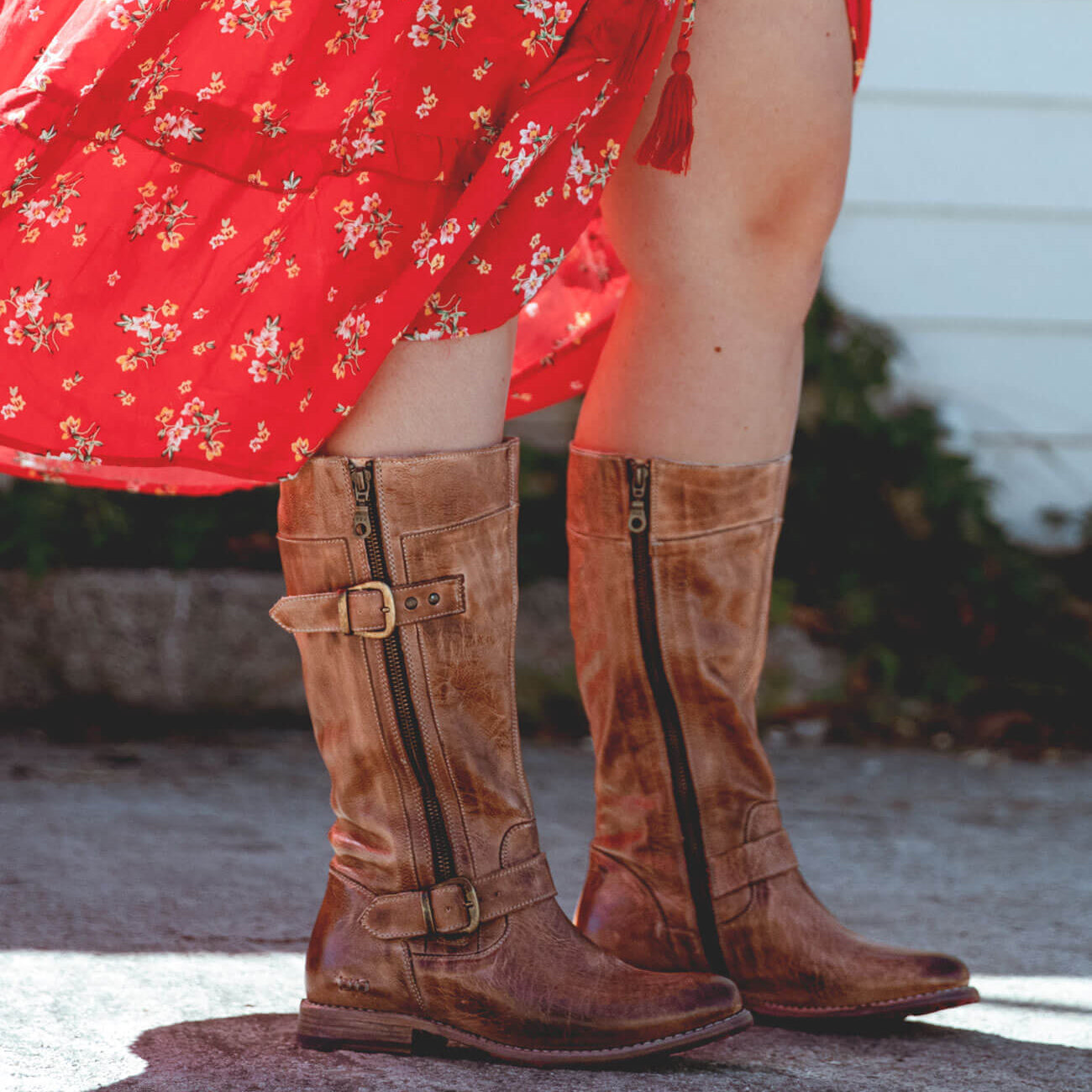 A woman wearing a red dress and Bed Stu Gogo Lug Wide Calf boots.
