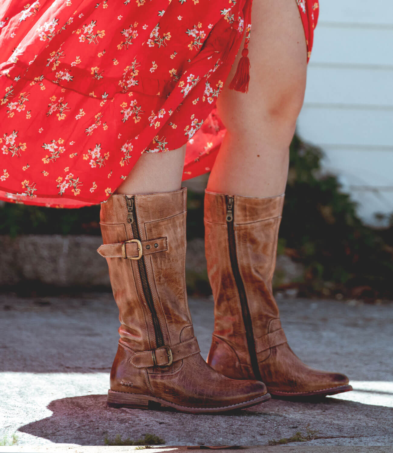 A woman wearing a red dress and Bed Stu Gogo Lug Wide Calf boots.