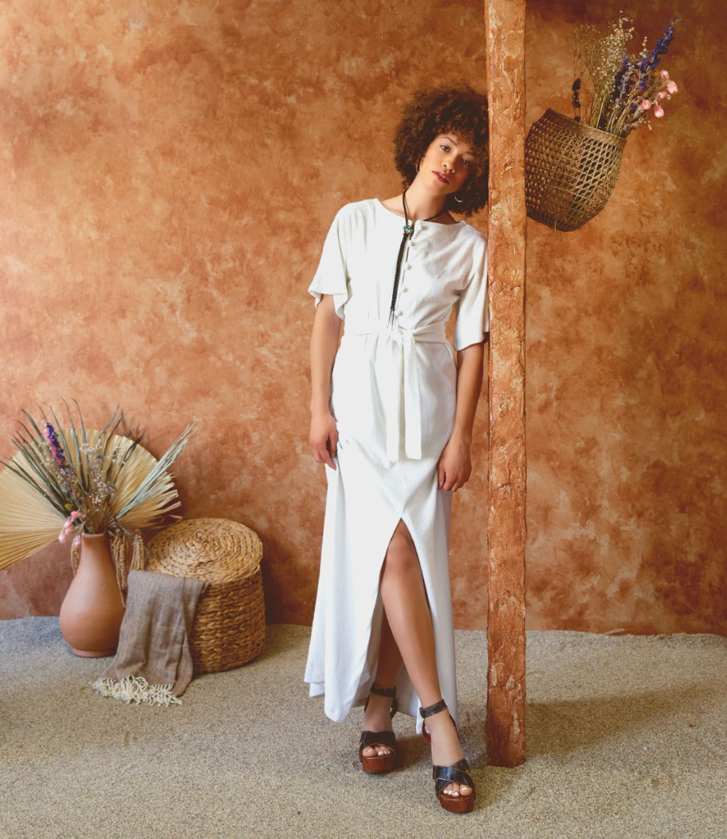 A woman wearing a white dress and Bed Stu Grettell sandals.