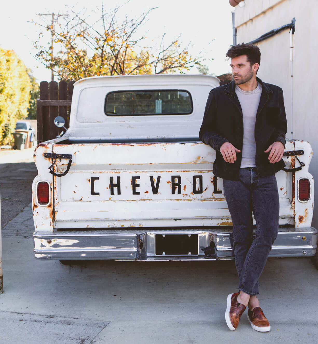 A man leaning against a white Bed Stu Harry truck.