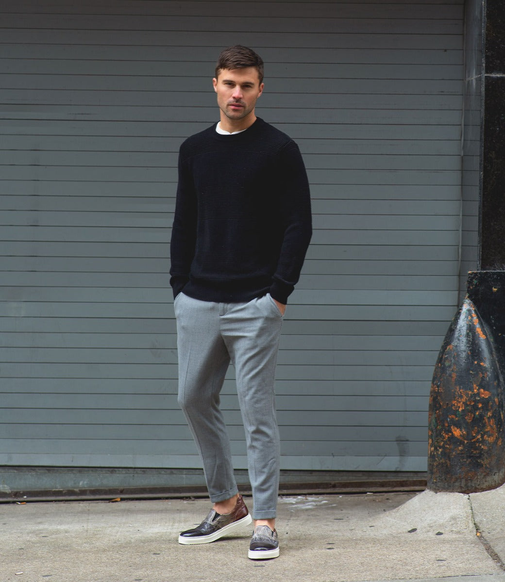 A man wearing a black sweater and gray Harry pants from Bed Stu.