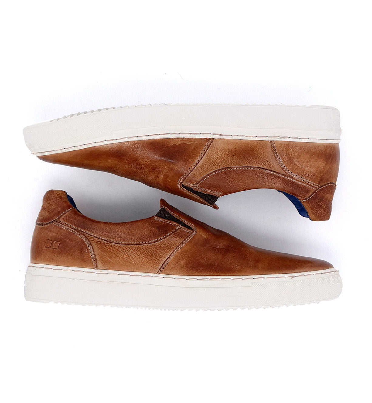 A pair of brown Harry slip on sneakers on a white background.
