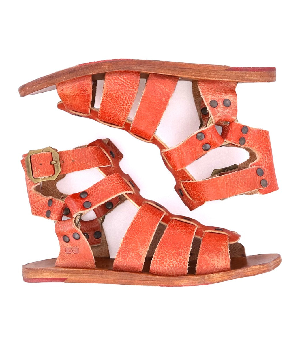 A pair of Bed Stu Hera orange sandals with buckles and straps.