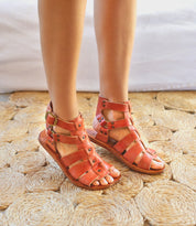 A woman wearing Bed Stu Hera sandals standing.