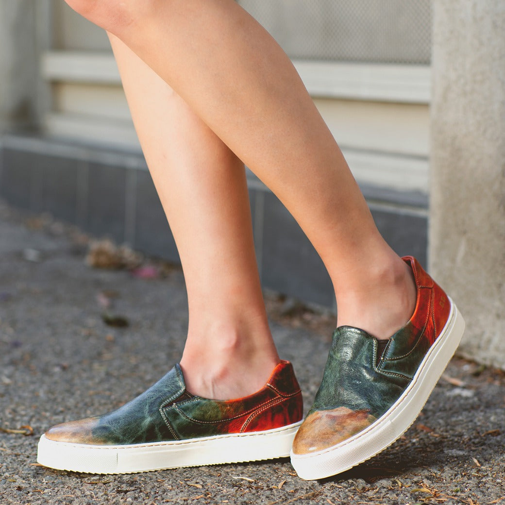 A woman wearing a pair of colorful slip on sneakers called Hermione by Bed Stu.
